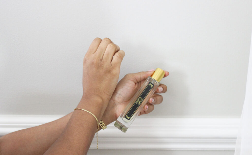 Applying Tijon perfume holding perfume bottle