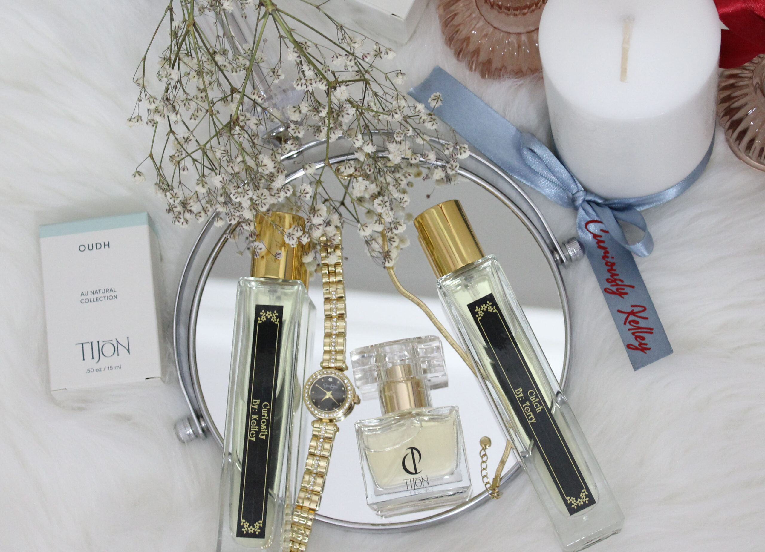 Tijon custom perfume bottles on mirror with baby's breath flowers.